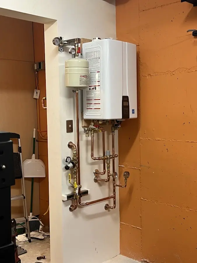 Plumbing technician inspecting water heater connections in Downey
